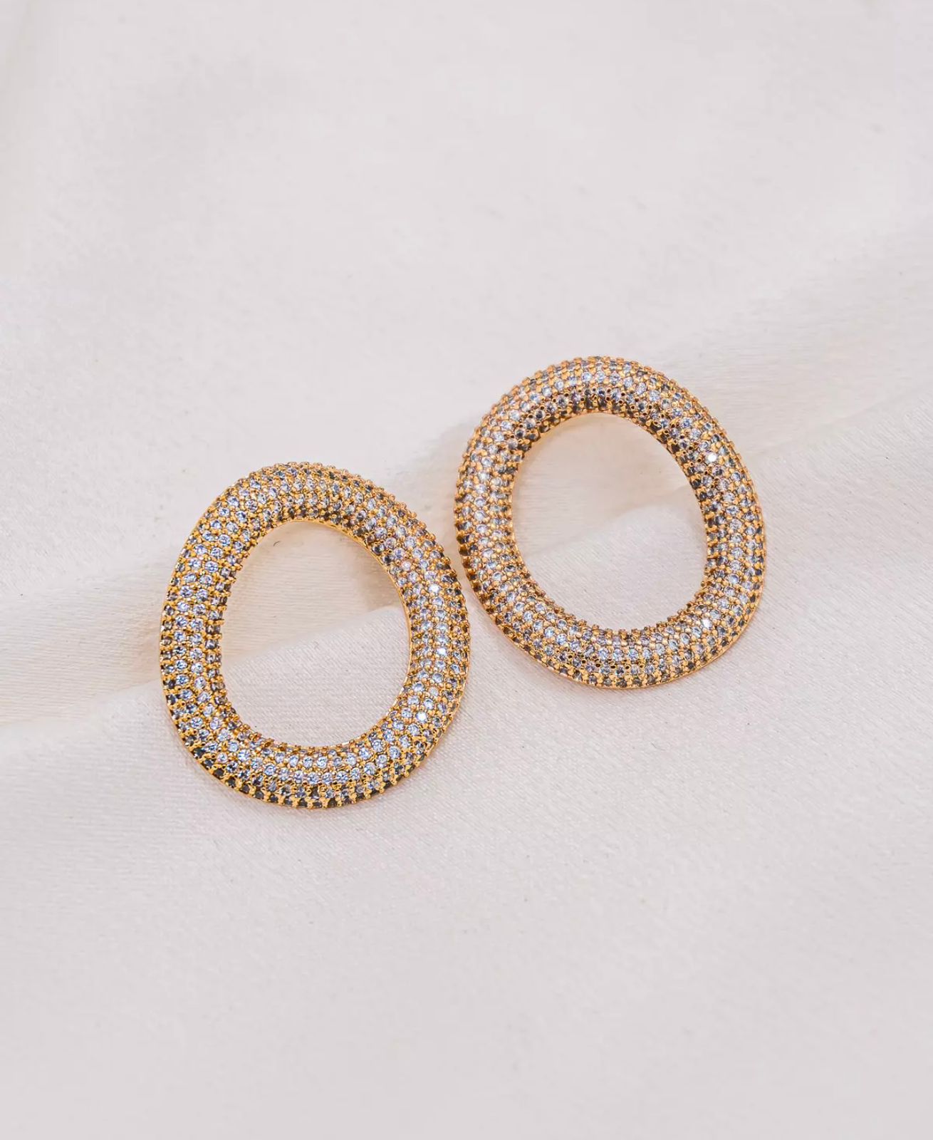 Brinco oval dourado todo cravejado