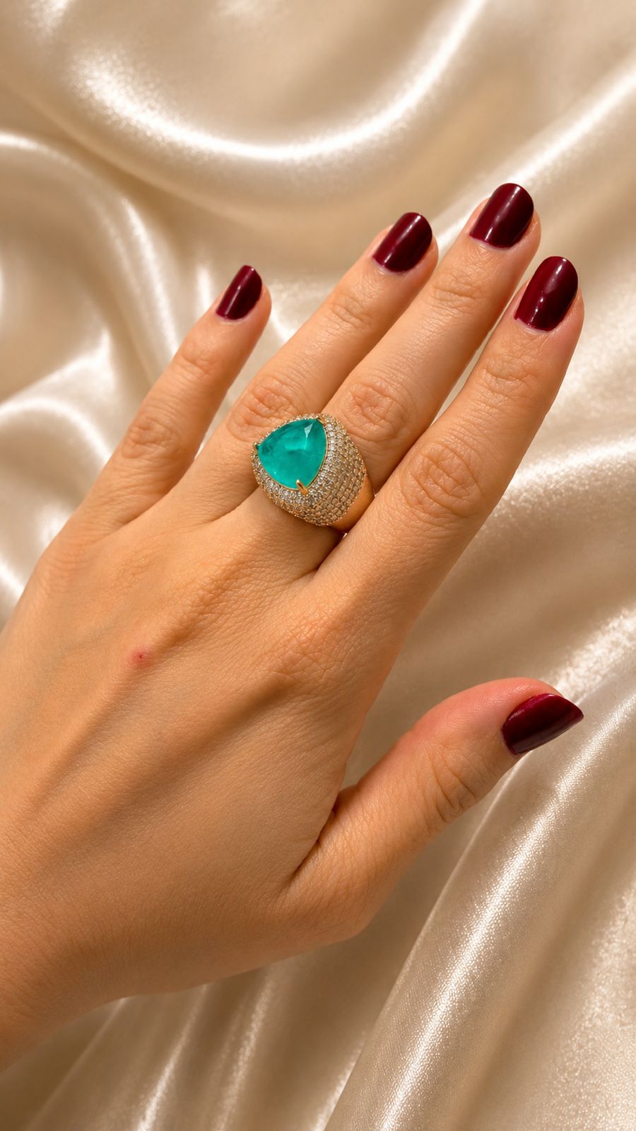 Anel dourado com pedra verde em gota e zircônias