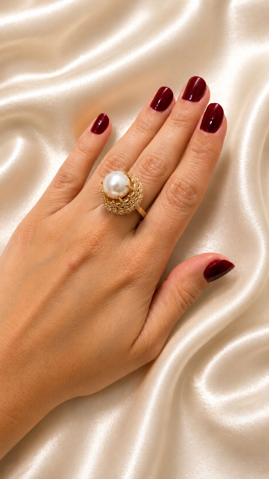 Anel dourado com pérola central e detalhe em ninho