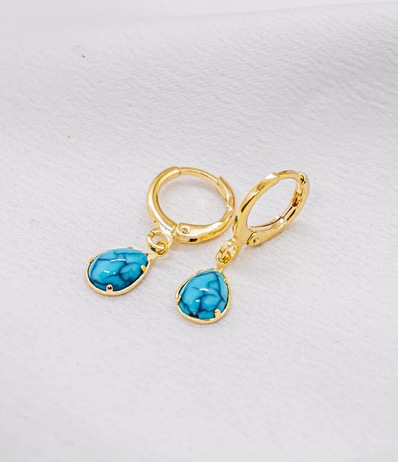 Brinco argola dourada com gota azul