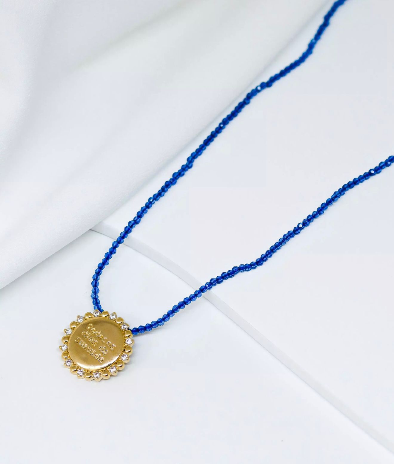 Colar de cordão azul com medalha em banho de ouro e zircônias